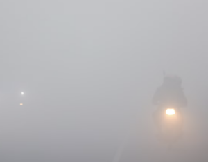 Commute in the dense early morning fog in Delhi