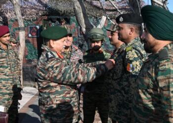 Army Chief pins a decoration on a soldier while interacting with troops at a forward post in a border area.